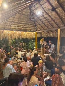 a group of people sitting at tables in a restaurant at Tahini and Friends Surf, Yoga & Wellness in Ahangama