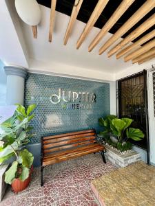 a wooden bench sitting in a room with plants at Jupiter Homestay in Cabanatuan
