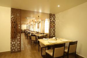 Zaki Hotel Apartment في صور: غرفة طعام مع طاولات وكراسي في مطعم