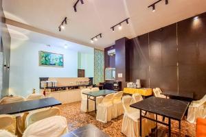 a restaurant with tables and chairs in a room at Abbas Syariah Hotel near Menara Kudus Mitra RedDoorz in Kudus