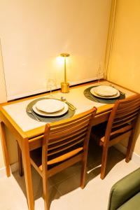 a table with two plates and two wine glasses on it at Loft moderno e aconchegante no coração de Icaraí in Niterói +37 photos