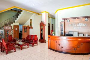 a lobby with a bar and chairs and a clock at Abbas Syariah Hotel near Menara Kudus Mitra RedDoorz in Kudus