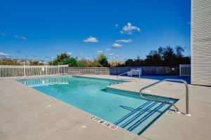 a large swimming pool with a metal rail around it at Surf City Stay Motel Unit - Walk to Beach in Surf City