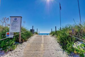 a wooden path leading to the beach with a sign at Surf City Stay Motel Unit - Walk to Beach in Surf City