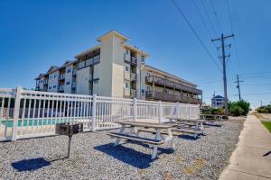 a group of picnic benches in front of a building at Surf City Stay Motel Unit - Walk to Beach in Surf City +4 photos