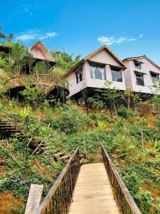 a house on top of a hill with a wooden bridge at Bamboo Hill Resort in Hữu Lũng