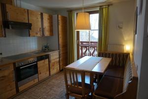 a kitchen with a wooden table and a dining room at Appartements Huber in Altenmarkt im Pongau