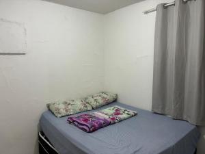 a bed with two pillows on it in a room at Proximo ao Shopping e Aeroporto 2 Quartos com Ar e TV a Cabo in Várzea Grande