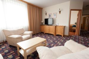 a living room with a couch and a tv at Hotel Partner in Warsaw