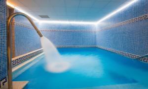 a swimming pool with a blue shower curtain at Hotel Xalet Montana in Soldeu