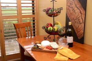 einen Tisch mit einem Obstteller und einer Flasche Wein in der Unterkunft Broken View Estate in Pokolbin