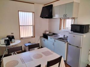 a small kitchen with a table and a refrigerator at Winston in Chiba