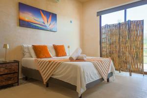 a bedroom with a bed and a large window at In Wotoch Chicxulub by Casago in Chicxulub +49 photos