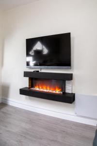 a fireplace with a tv on a wall at Unit 3 Modern Self Contained Apartment in Cobh