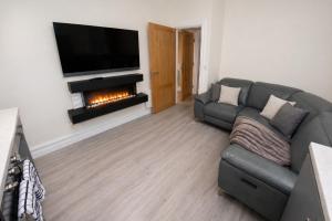 a living room with a couch and a fireplace at Unit 3 Modern Self Contained Apartment in Cobh
