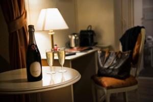 een fles champagne en twee glazen op een tafel bij Relais Bocca di Leone in Rome