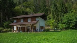 a small house with a brown roof in a field at Casa al Portico in Ledro