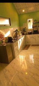 a kitchen with white cabinets and green walls at Valley homestay Dalat in Da Thien