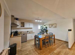 a kitchen with a table and chairs in a room at Ecrin au milieu des vignes in Uchaux +2 photos