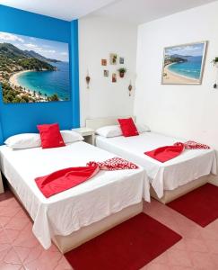 two beds in a room with a view of the ocean at Hotel Zihua Malibu in Zihuatanejo