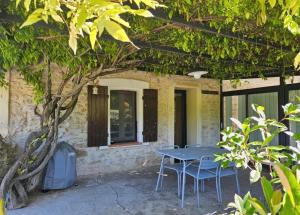 a table and chairs in front of a building at Ecrin au milieu des vignes in Uchaux