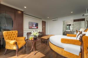 a hotel room with a large bed and chairs at ORA Hotel in Văn La
