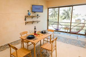 a dining room with a table and chairs at In Wotoch Chicxulub by Casago in Chicxulub