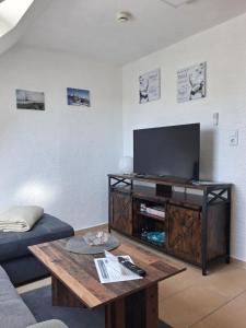 a living room with a tv and a coffee table at Haus Morgenstern Fewo Boben in Neuharlingersiel