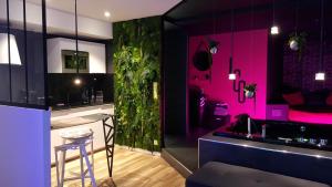 a kitchen with pink walls and a bar with a stool at Le Clair Obscur in Nantes