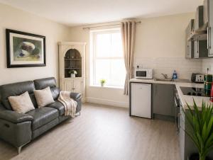 a living room with a couch and a kitchen at Unit 1 Island View Apartments - Town Centre Walk To Everything in Cobh
