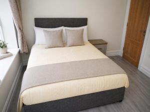 a bedroom with a large bed with pillows at Unit 1 Island View Apartments - Town Centre Walk To Everything in Cobh