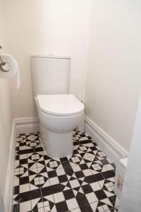 a bathroom with a toilet and a checkered floor at Unit 1 Island View Apartments - Town Centre Walk To Everything in Cobh