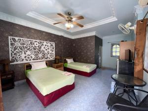 a bedroom with two beds and a ceiling fan at SouanSonBeachResort in Klaeng +16 photos