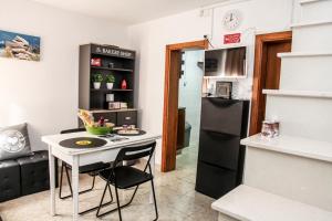 a small kitchen with a table and a refrigerator at SwordFish Holiday Home in Peniche