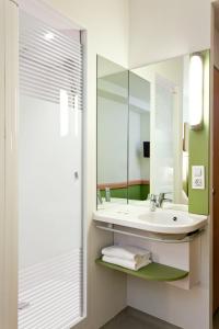 uma casa de banho com um lavatório e um espelho em ibis budget Hamburg Altona em Hamburgo