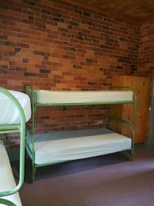 
a small room with a bunk bed and a bench at Mansfield Travellers Lodge in Mansfield
