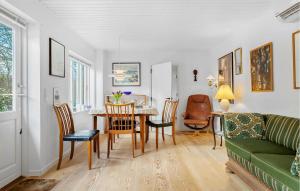 a living room with a table and a green couch at Nice Home In Samsø With Wifi in Ballen