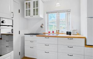 a kitchen with white cabinets and a window at Nice Home In Samsø With Wifi in Ballen
