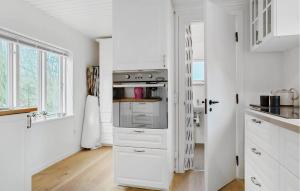 a kitchen with white cabinets and an oven at Nice Home In Samsø With Wifi in Ballen