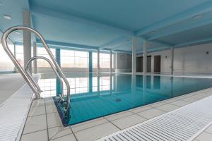 a large swimming pool with blue tiles in a building at Świętokrzyska Polana - Medical Resort in Chrusty