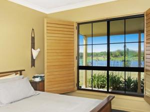 um quarto com uma cama e uma janela grande em Broken View Estate em Pokolbin