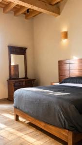 a bedroom with a bed with a wooden headboard and a mirror at Suite Privada Nueva Boutique con Entrada Independiente y Acceso Autónomo, A 5 Min del Centro in Pátzcuaro