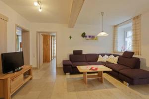 a living room with a couch and a tv at Ferienhaus Wimbauer in Nennslingen