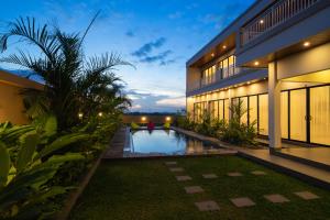 an exterior view of a house with a swimming pool at Pondok Uma Jero in Tanah Lot