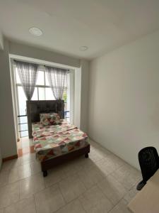 a bedroom with a bed in a room with a window at Texworks Coliving in Cali