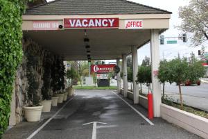 a car dealership with a vacancy sign in a parking lot at Caravelle Inn Extended Stay in San Jose +5 photos
