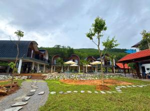 a resort with a yard with rocks and umbrellas at Green Valley Retreat in Phong Nha