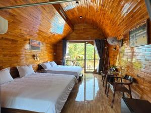 two beds in a room with a wooden ceiling at Green Valley Retreat in Phong Nha