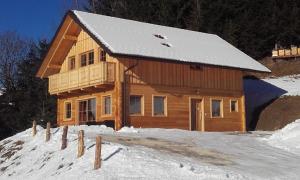 ein großes Holzhaus im Schnee mit Schnee in der Unterkunft Bio Chalet "Sonne" in Weisspriach