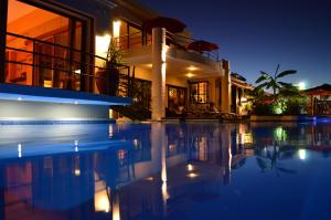 a house with a swimming pool at night at Le Gite du Bonheur Guest House & Car Rental in Tamarin
